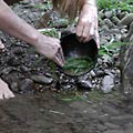 Washing dishes in a creek with sand